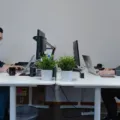 Pekerja kantor menerapkan tips menjaga kesehatan di tempat kerja dengan peregangan ringan