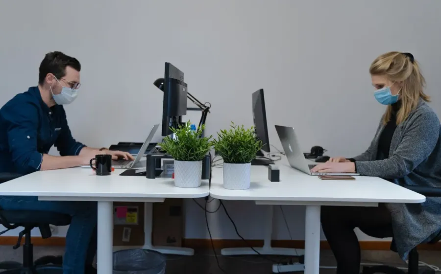 Pekerja kantor menerapkan tips menjaga kesehatan di tempat kerja dengan peregangan ringan
