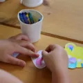 Seorang anak perempuan sedang asyik menggambar di lantai untuk mengatasi anak bosan di rumah