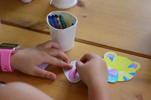 Seorang anak perempuan sedang asyik menggambar di lantai untuk mengatasi anak bosan di rumah