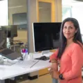 Pekerja kantor menerapkan tips menjaga kesehatan tubuh saat bekerja dengan duduk tegak di depan laptop