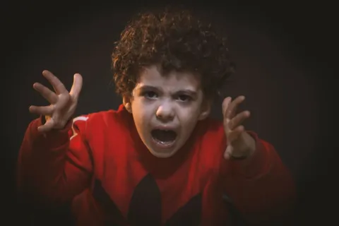 Ibu sedang menerapkan cara membantu anak mengelola emosi saat anak merasa kesal di ruang keluarga