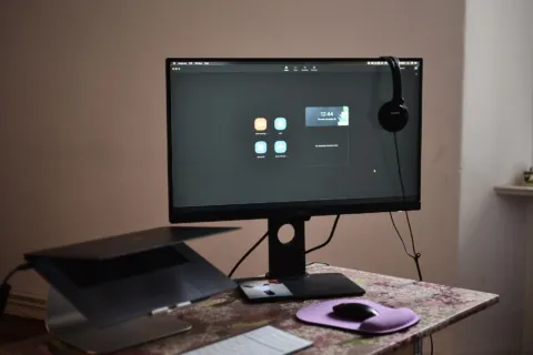 Set up meja kerja minimalis dengan monitor tambahan yang sejajar dengan pandangan mata