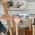 Seseorang sedang mengambil hasil cetakan kertas dari printer untuk rumah di atas meja kerja