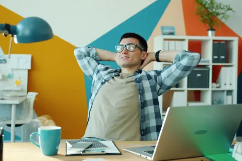 Pekerja mematikan laptop kantor untuk menjaga keseimbangan kerja dan hidup di rumah
