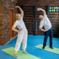 Seseorang sedang meregangkan kaki dan lutut di pagi hari untuk tips menjaga kesehatan tulang dan sendi