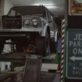 Seseorang sedang mempraktikkan tips merawat mobil di garasi rumah dengan mengecek kondisi ban